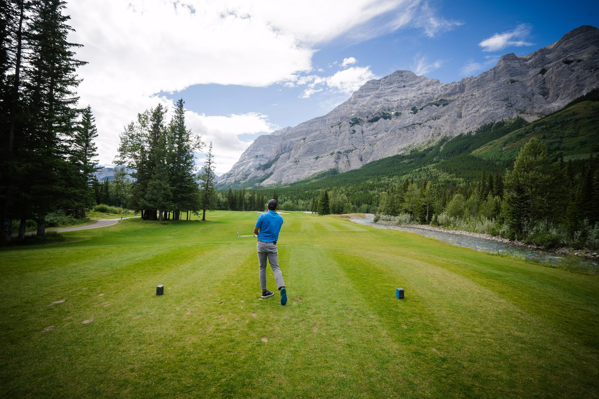 A golfer playing on a mountain-backed course