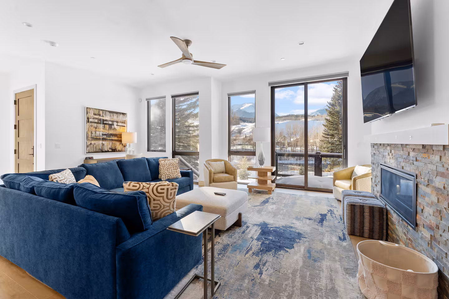 Light-filled living room with blue sofas and mountain views