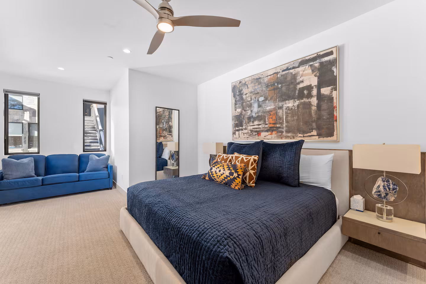 Bedroom with blue bedding and sofa